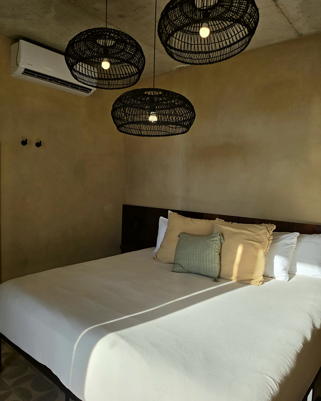 Guest room at Equ, woven pendants above the bed