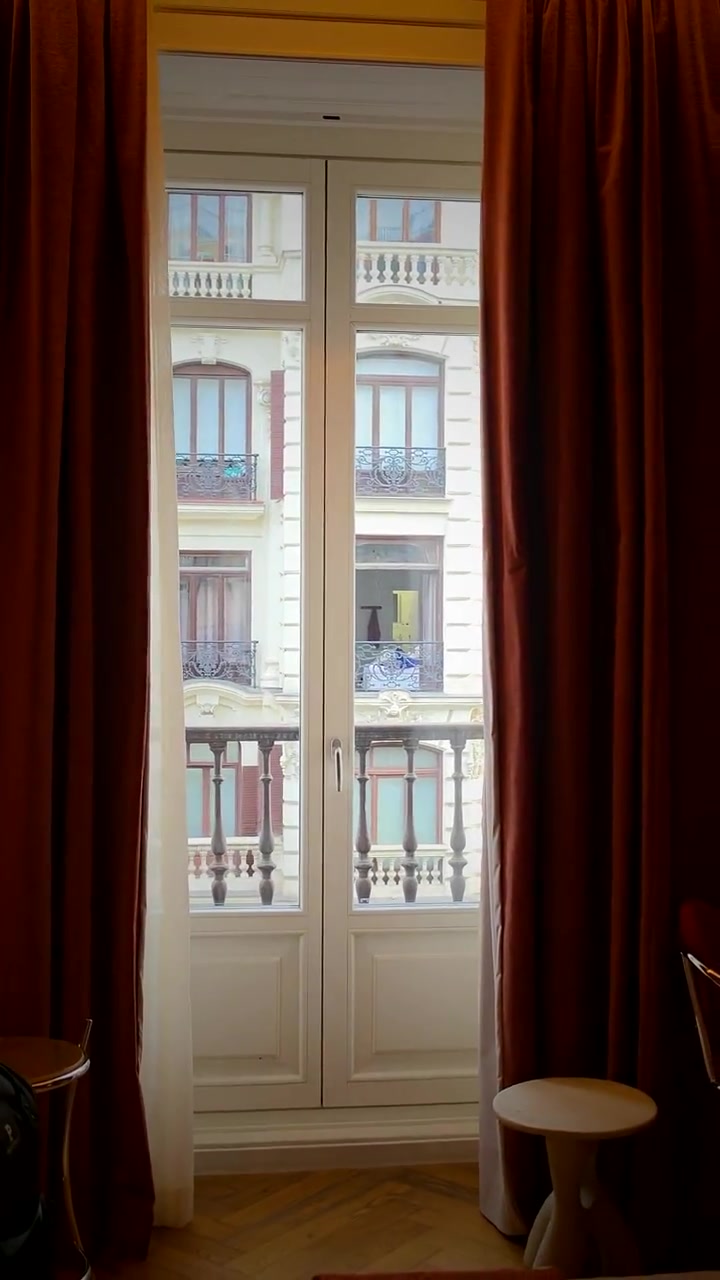 Balcony doors open onto a Madrid street