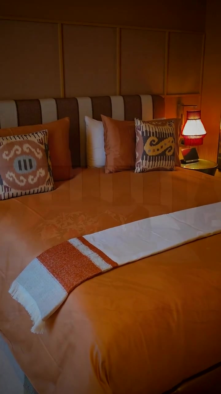 The bed at Nomade Temple under warm lamplight